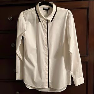 White blouse with brown/black edging detail on collar and down front.
